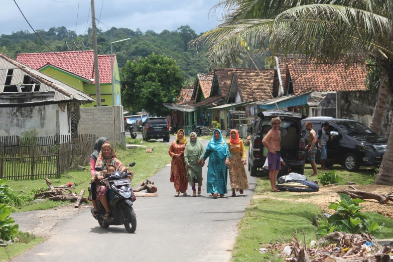 a group of people walk down the street together