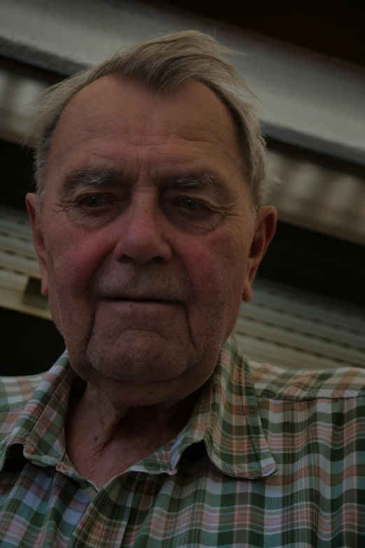 an older man poses for the camera and has a skeptical look on his face