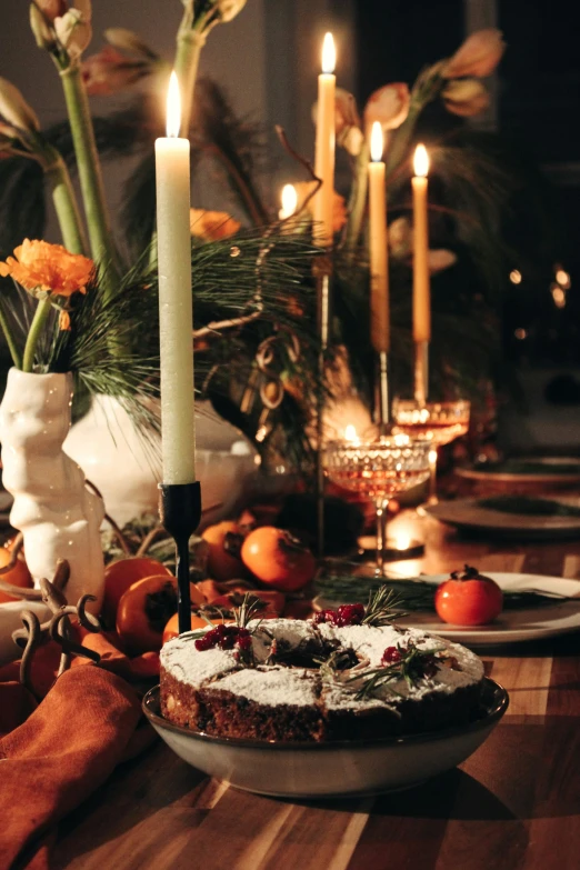 a dessert with icing, oranges and a white candle sitting next to it