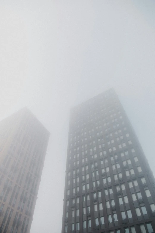 two very tall buildings in the fogy city