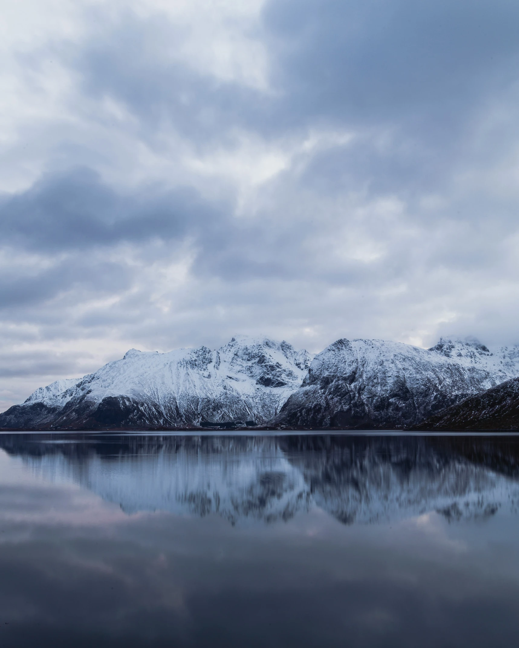 the mountain range is covered in snow and clouds