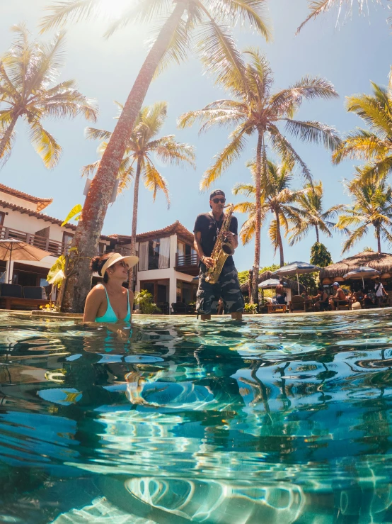 man standing near swimming pool with dogs and buildings