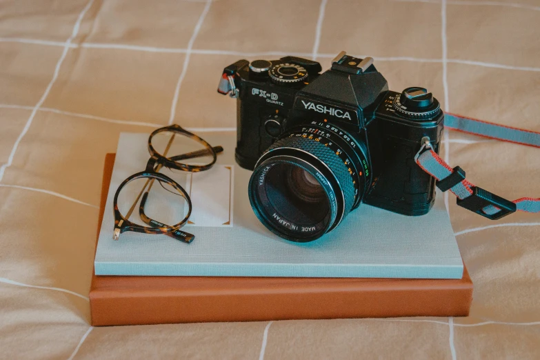 a camera with a pair of glasses sitting on a wooden coaster