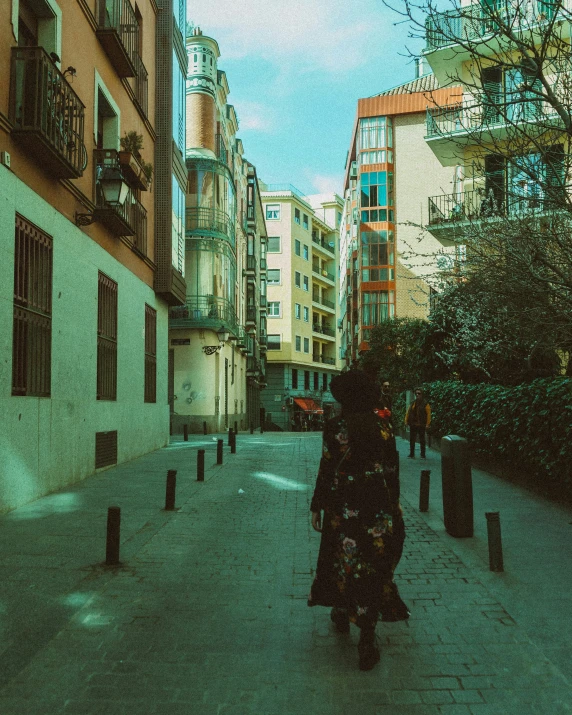 a woman stands in the middle of an alleyway in the city