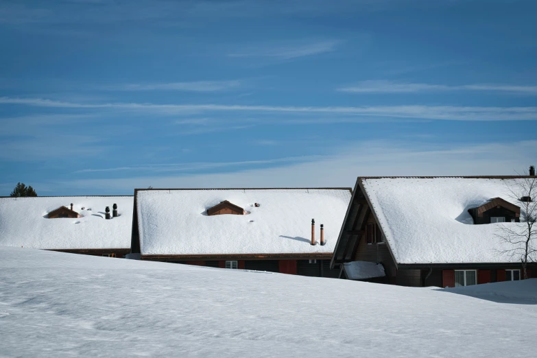 two large buildings with covered in snow on a sunny day