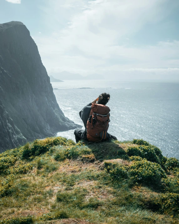 a person is standing on top of a hill by the water