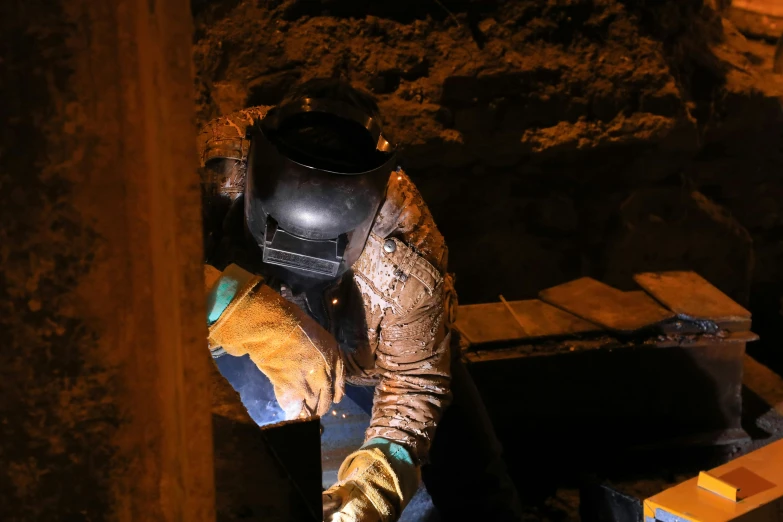 a worker wearing protective clothing holds up soing