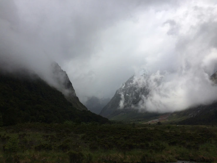 a cloudy view of mountains and valley in the distance