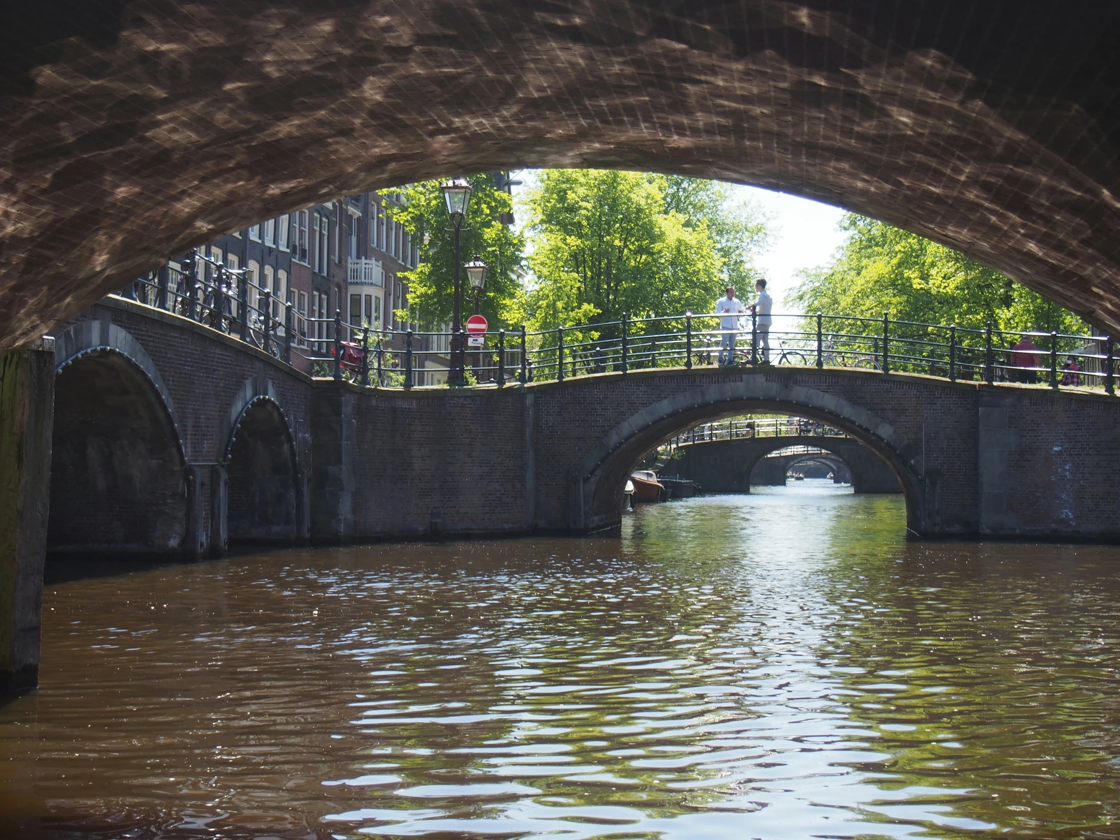 an arched walkway above the water leading to some bridges