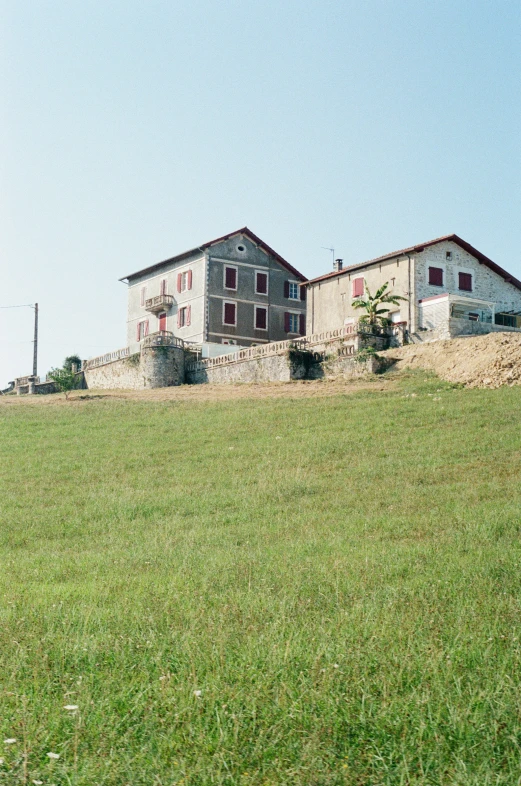 a house on a hill with grass and dirt