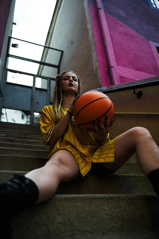 a female basketball player wearing yellow is sitting down