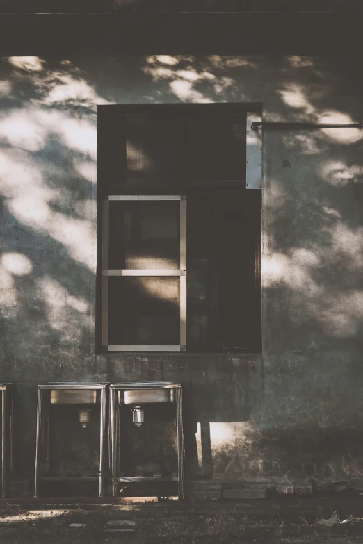 an empty bench sits on a sidewalk next to a wall