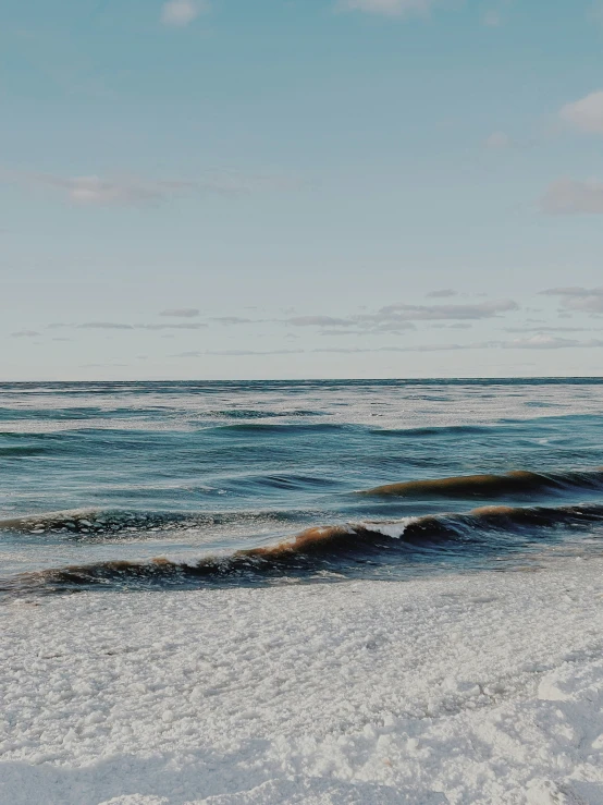 a person riding a horse along the beach with the ocean