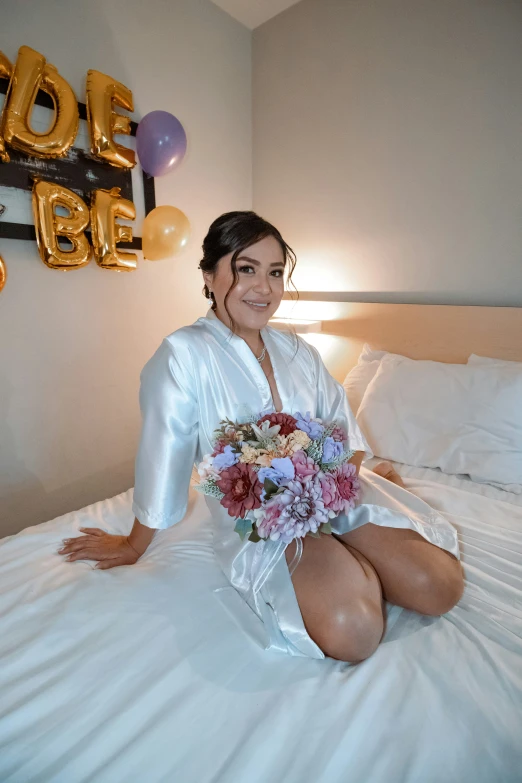 a woman wearing white is on a bed with flowers