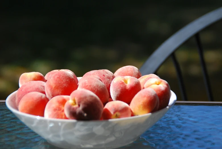 a bowl of peaches is on the table