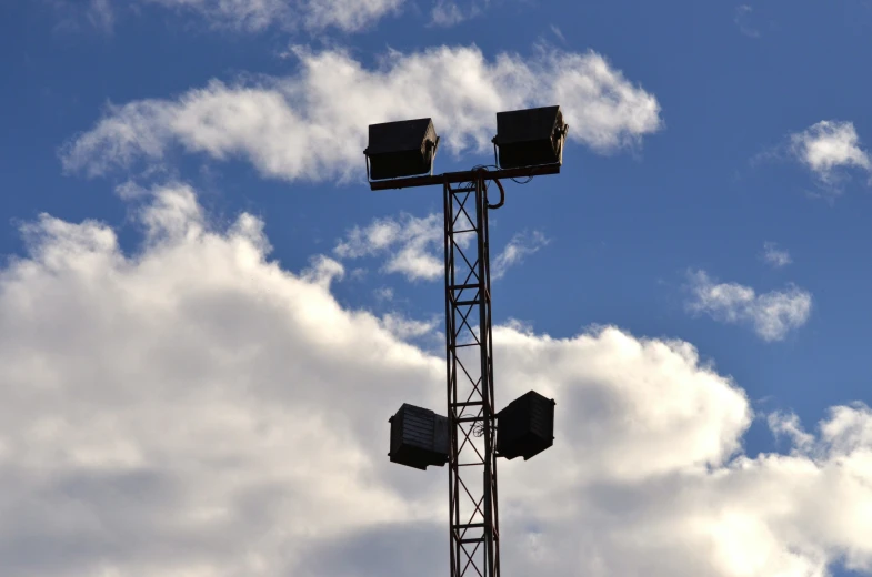 two square lights in the sky on a metal pole