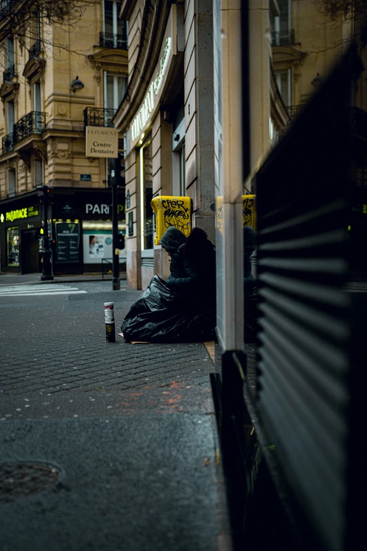 a black homeless man is sitting on the curb with trash