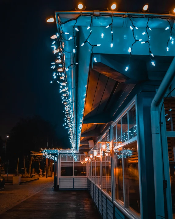 a large open area has string lights and blue glass