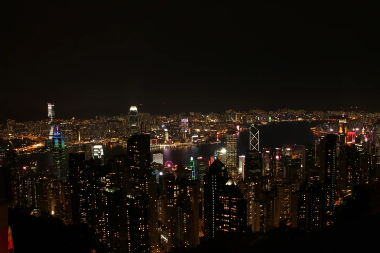 hong kong skyscrs at night and city lights in the foreground