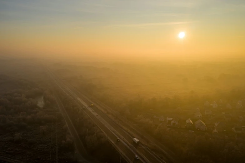 a railroad line with trains at sunset with the sun coming up