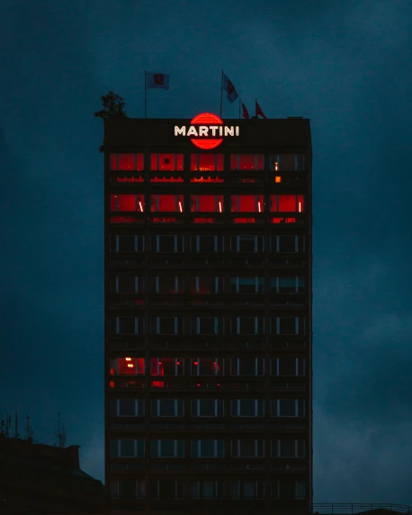 a night view of a building with the words martini lit in red