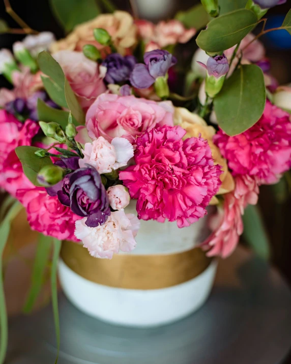 a white cup with some pretty pink and purple flowers in it