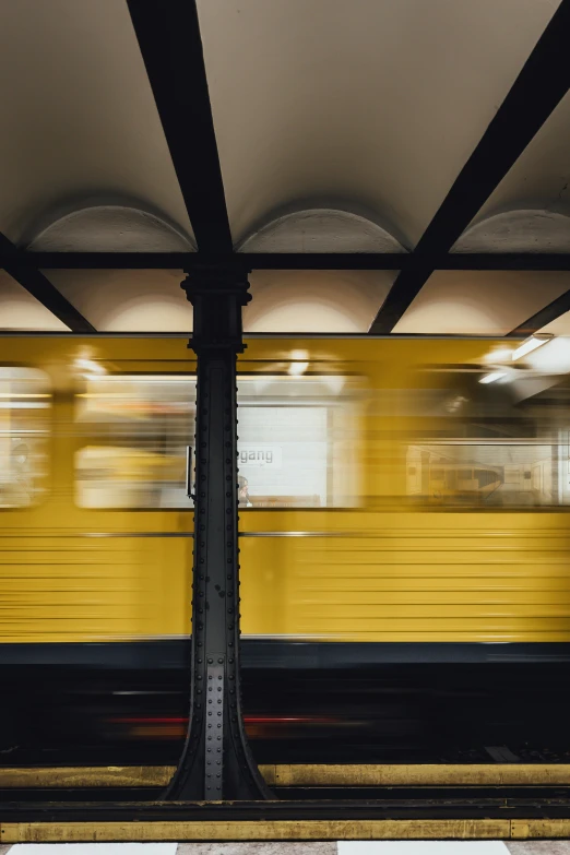 two yellow trains passing by each other in an empty station