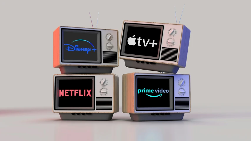 four different old televisions and a apple tv