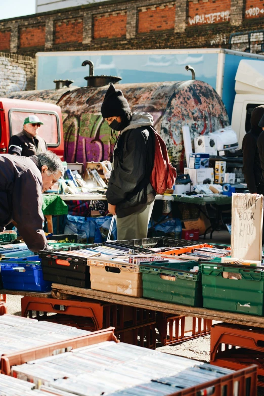 an outdoor flea market with vendor and their goods