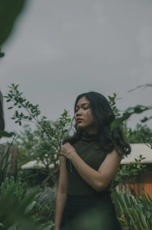 a woman is standing outside in front of some trees