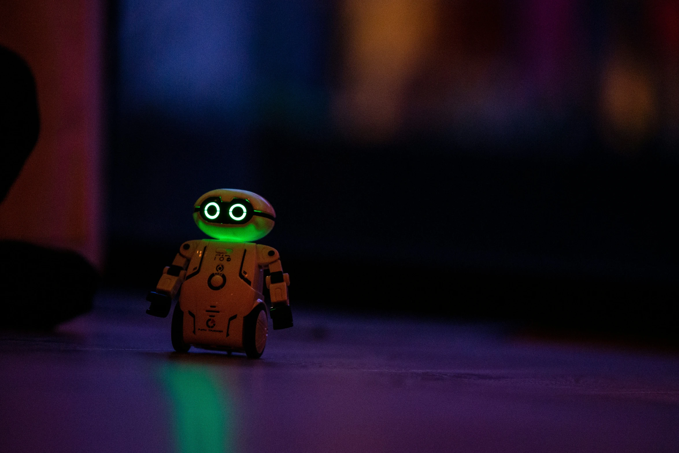 a little robot on the ground with a blurry background