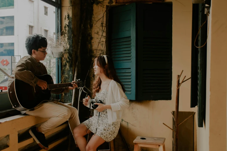 two people are playing instruments together on a balcony