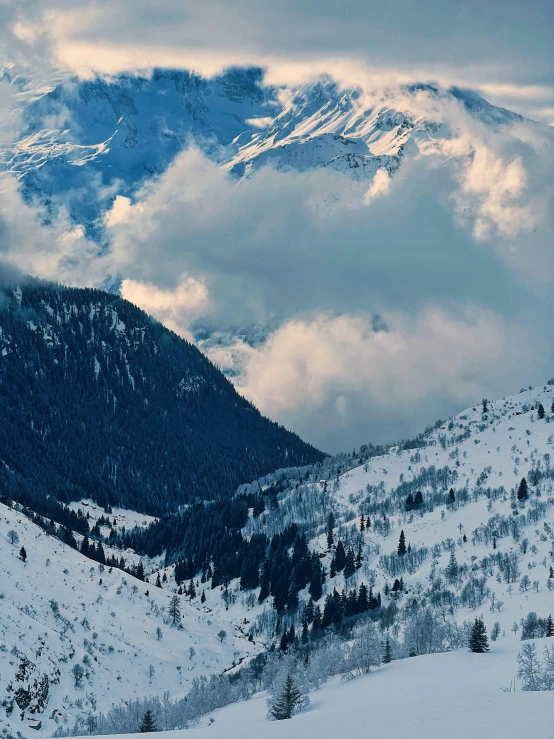 snowy mountains are seen with clouds in the background