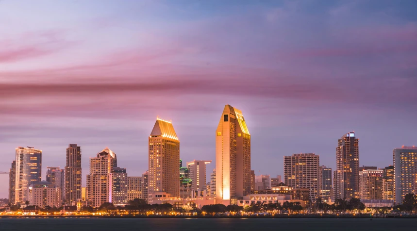 the city is illuminated up at night with clouds and lights