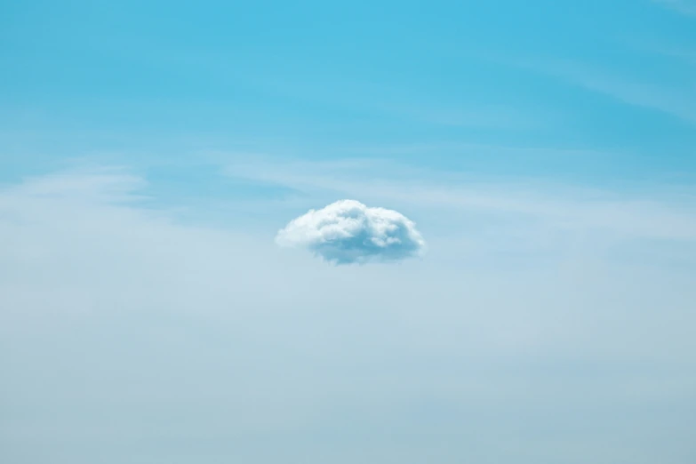 a cloud is in the blue sky on a sunny day