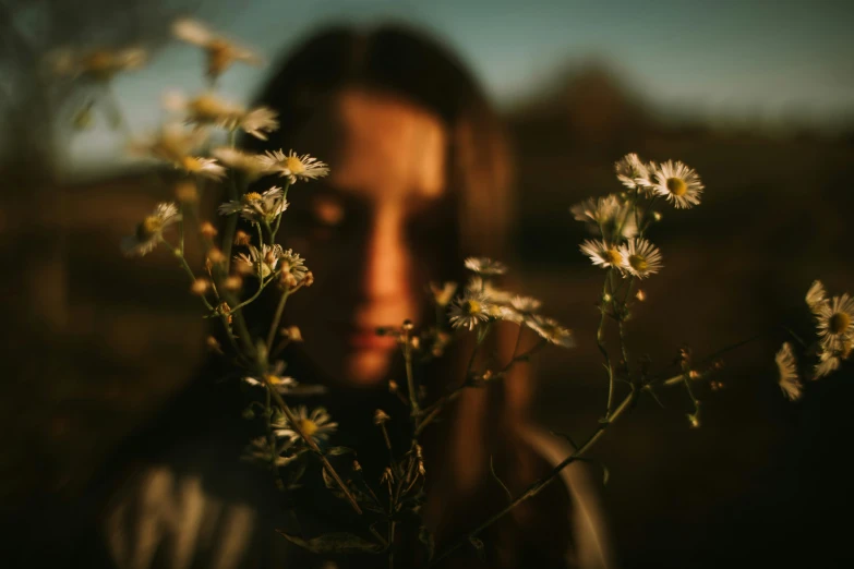 a girl in black shirt looking at flowers