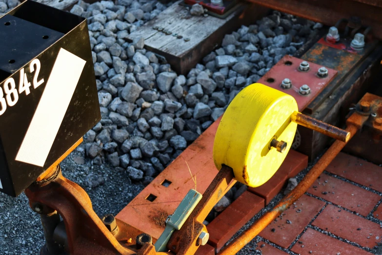 a metal tool sits next to gravel and rocks