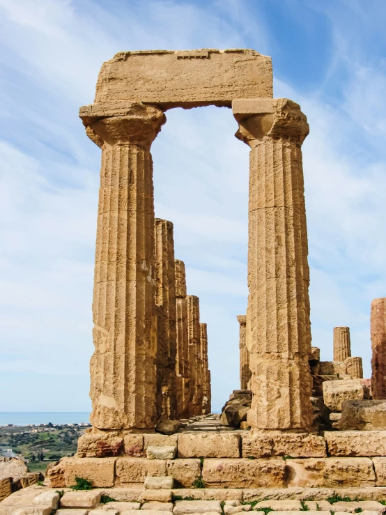 ancient structure with pillars at near by on grassy area