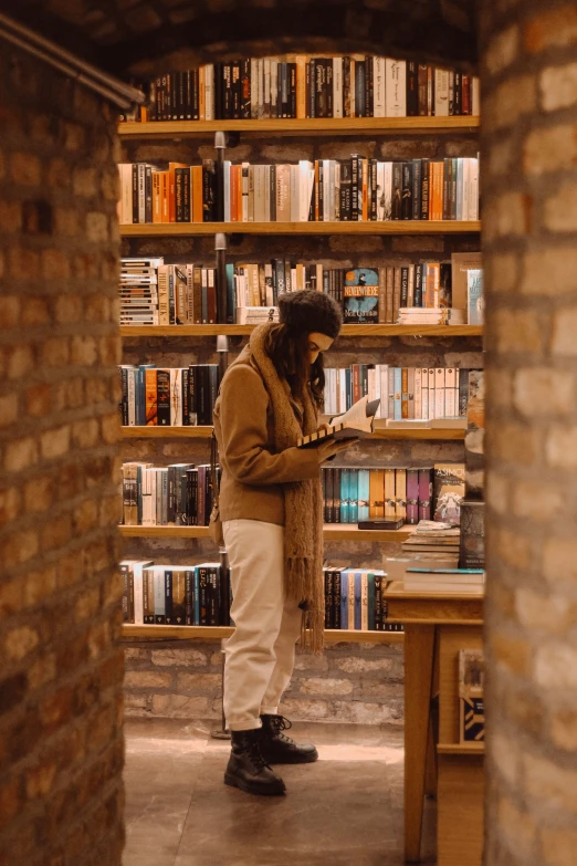 there is a man that is standing in front of the book shelves