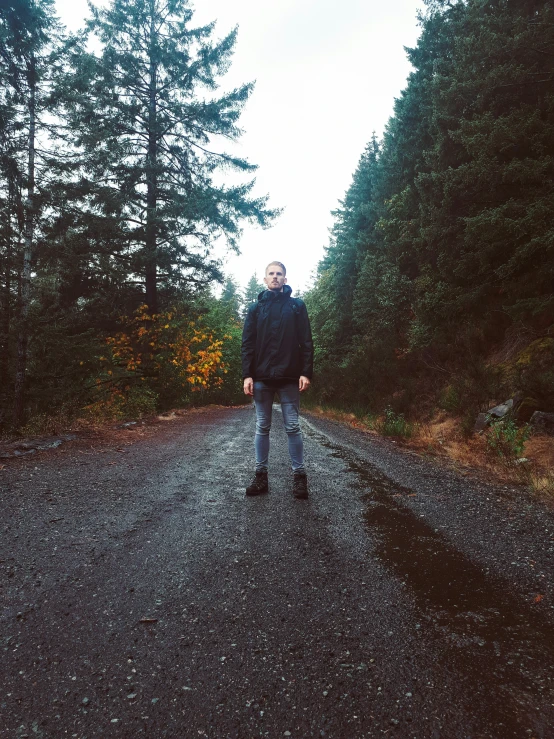 a man in a blue coat is walking down the road