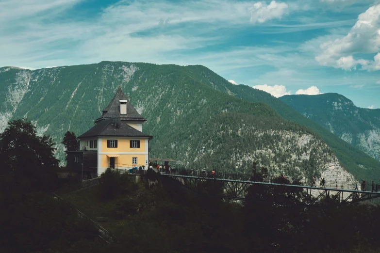 a yellow building sits in front of some mountains