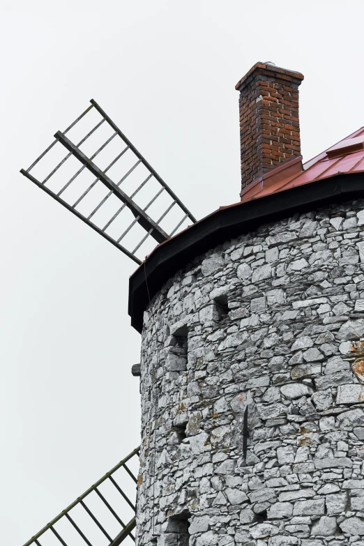 a brick tower with a tv antenna next to a metal structure