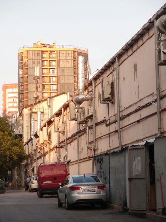 cars parked on the side of the road near some buildings