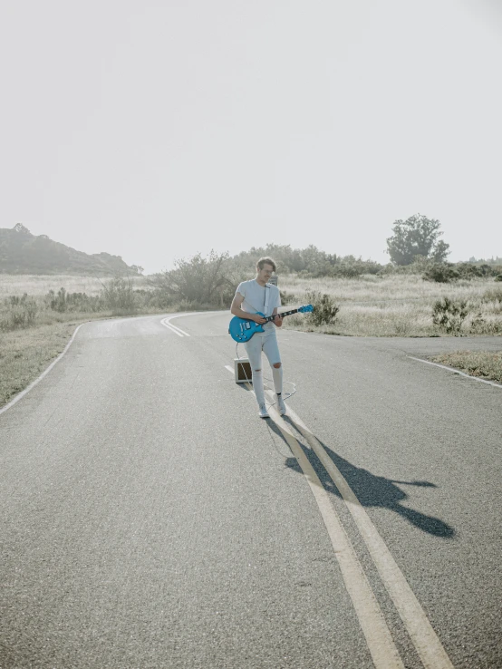 a man walking down a road with a book