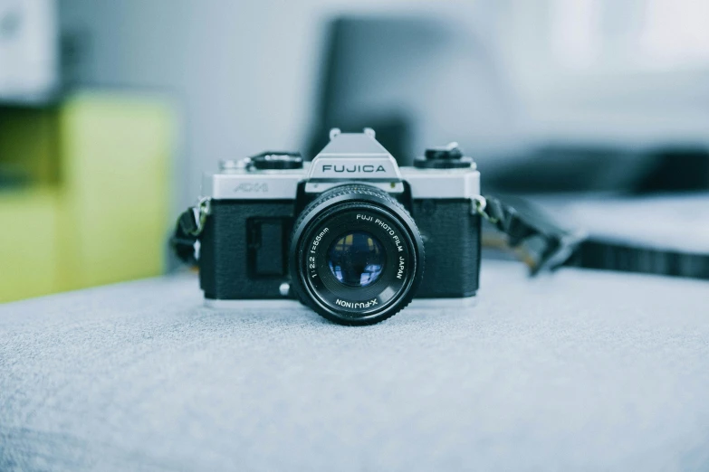 an old fashioned camera sitting on a white cushion