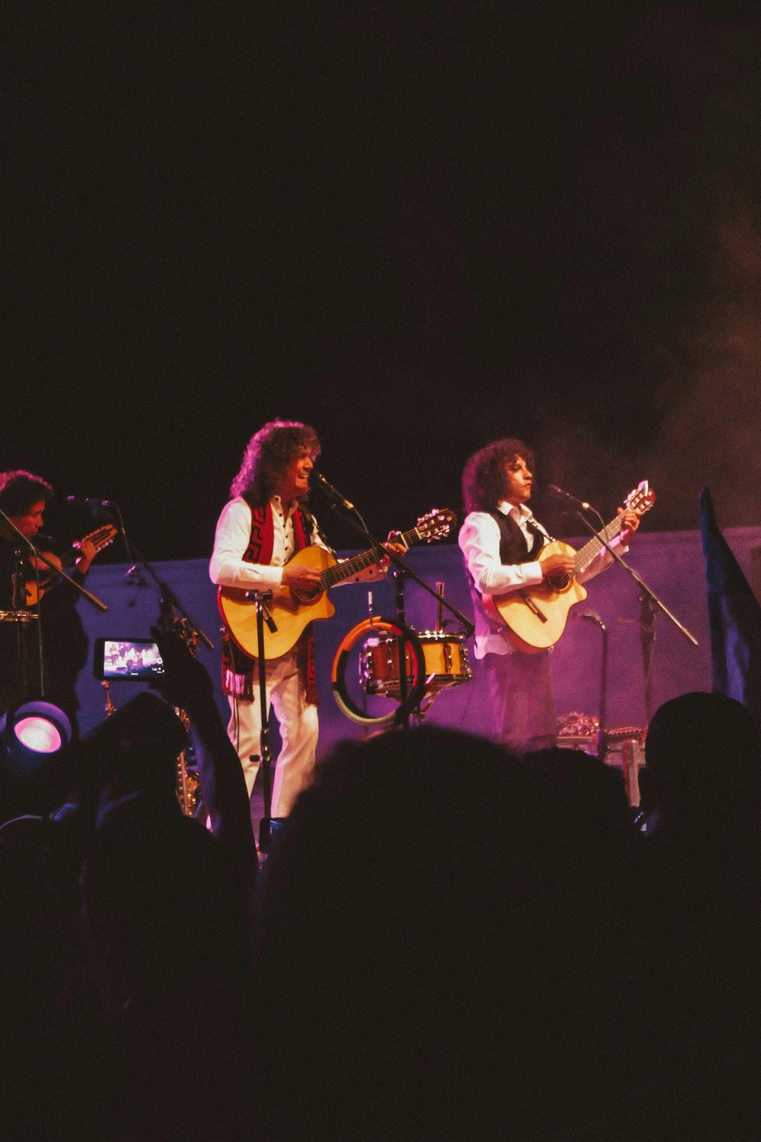 a man and woman are playing guitar in front of an audience