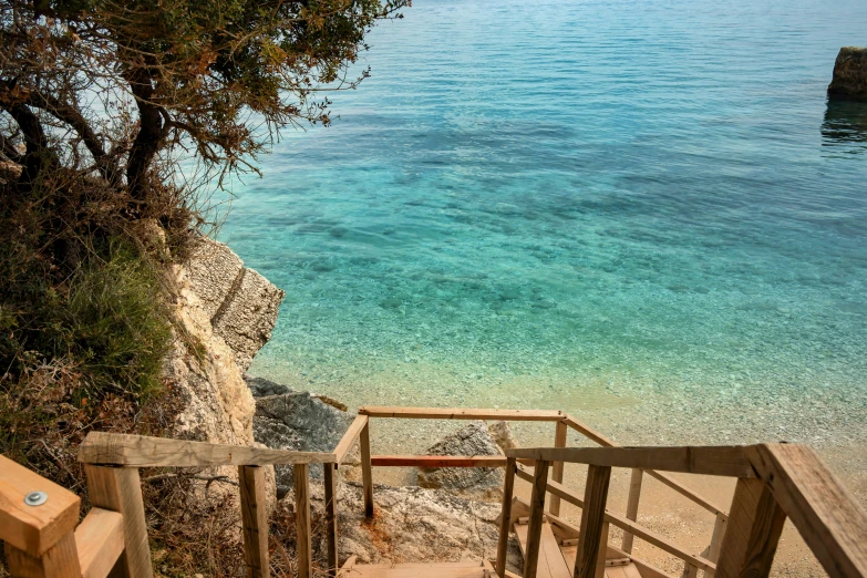 a wooden hand rail near a water way with steps