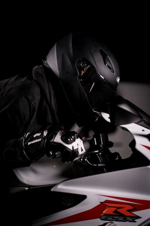 a person in black and white clothing sitting on a motorbike