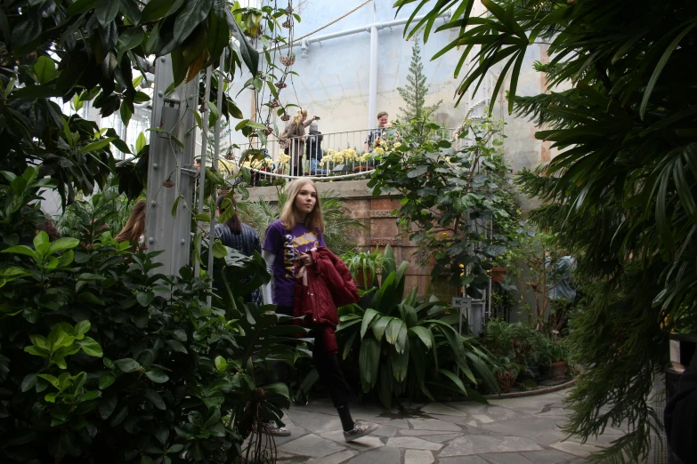 a woman standing in a large flower filled garden