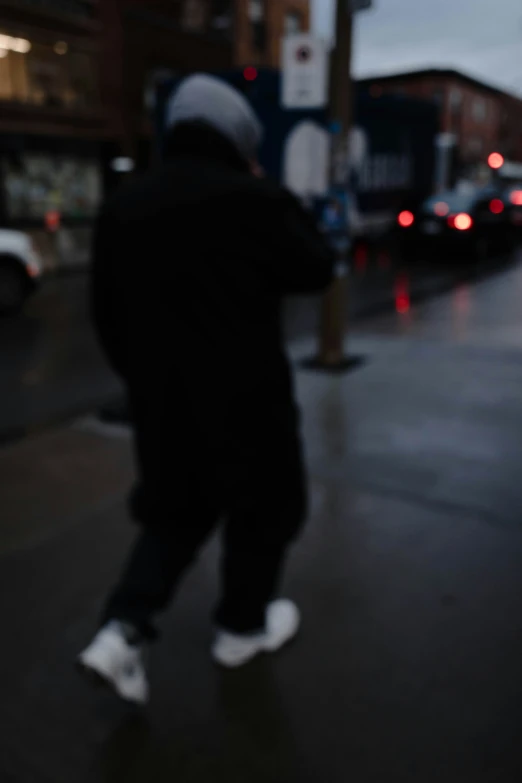 blurry pograph of a person walking on a city street at night